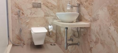 La salle de bains est pourvue d'un lavabo et de toilettes. dans l'établissement Shine Hospitality Group, à Mumbai