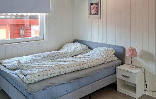 Beautiful Apartment In Hellvik With House Sea View في Hellvik: سرير عليه بطانية في الغرفة
