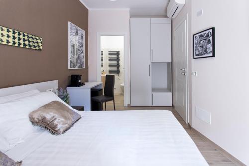 a bedroom with a white bed and a desk at MAMA GUEST HOUSE in Ciampino