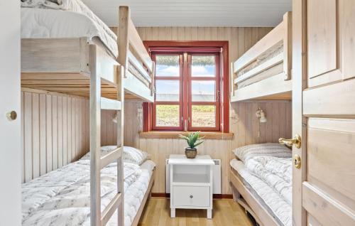 ヴィデ・サンデにあるBeautiful Home In Hvide Sande With 3 Bedrooms, Sauna And Wifiの窓付きの小さな部屋の二段ベッド2台分です。