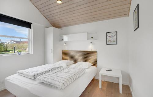 a white bedroom with a large bed and a table at Five-Bedroom Holiday Home In Rudkobing in Spodsbjerg