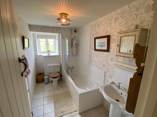 a bathroom with a tub and a toilet and a sink at Manor Farm House in Bristol