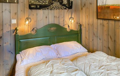 a bed in a room with a green headboard and lights at 4 Bedroom Gorgeous Home In Bjorli in Bjorli
