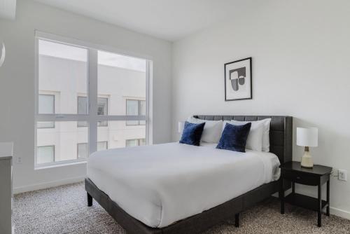 a white bedroom with a large bed and a window at Blueground Hayward pool outdoor kitchens SFO-1695 in Hayward