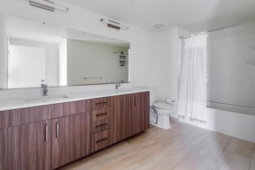 a bathroom with a sink and a mirror and a toilet at Blueground Hayward pool outdoor kitchens SFO-1695 in Hayward