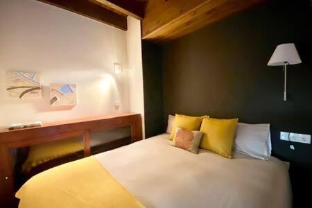 a bedroom with a white bed with yellow pillows at Apartament Pla de Masella in Alp