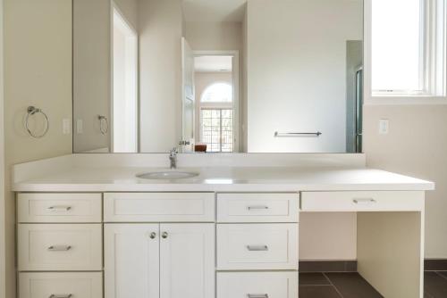 a white bathroom with a sink and a mirror at Blueground Burlingame wd ac near Caltrain SFO-1687 in Burlingame