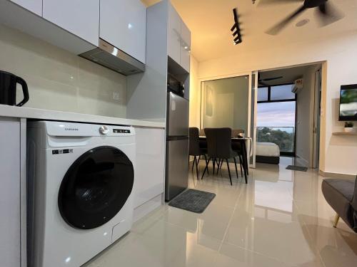 uma cozinha e sala de estar com máquina de lavar roupa em Modern luxury Home at The Shore by Mihome em Kota Kinabalu