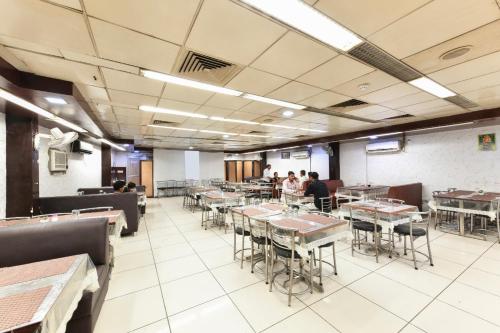 una sala da pranzo con tavoli e persone sedute ai tavoli di Hotel First by Goyal Hoteliers ad Agra