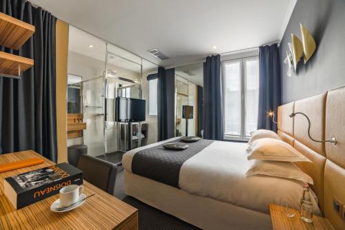 a hotel room with a large bed and a table at Hotel Residence Europe & Spa in Clichy