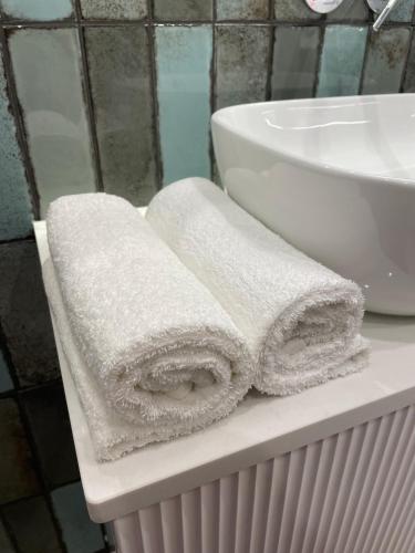 two towels sitting on a counter next to a sink at Imperial Citi Apartament in Krakow