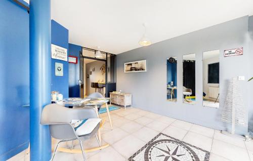 - un salon avec des murs bleus, une table et des chaises dans l'établissement Beautiful Apartment In Sainte-Adresse, à Sainte-Adresse
