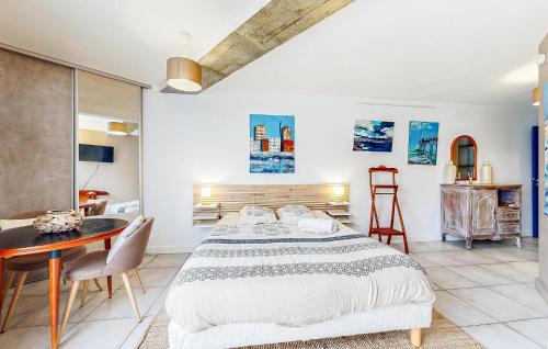 a bedroom with a large bed and a table at Cozy Apartment In Sainte-adresse With Wifi in Sainte-Adresse