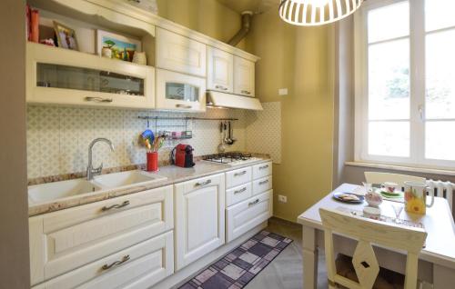 a kitchen with white cabinets and a sink and a table at Beautiful Apartment In Volterra in Volterra