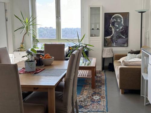 a living room with a table and a couch at Room in a private apartment in Nacka