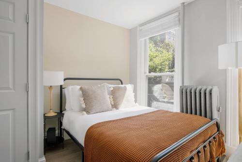 a white bedroom with a bed and a window at Beacon Hill studio nr boston common shops BOS-906 in Boston