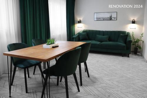 uma sala de estar com uma mesa de madeira e um sofá verde em Hotel Polonia Centrum em Breslávia