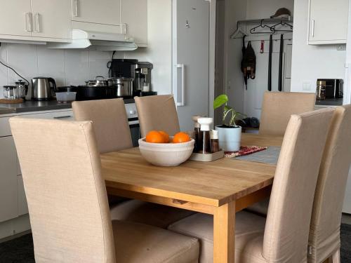 a wooden table with a bowl of oranges on it at Room in a private apartment in Nacka