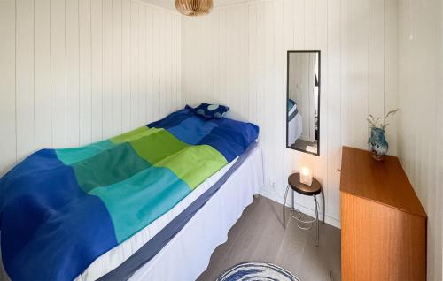 a bedroom with a bed with a colorful blanket at Cozy Home In Skjrhalden With House A Panoramic View in Skjærhollen