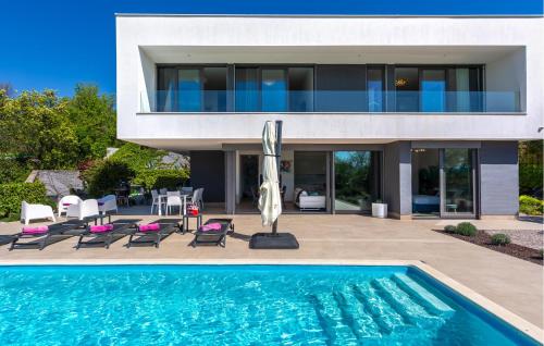 a house with a swimming pool in front of a house at Stunning Home In Malinska in Malinska