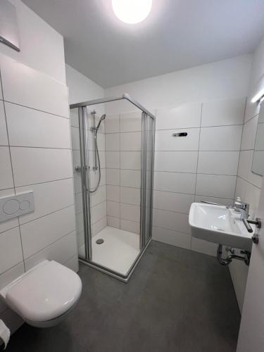 a bathroom with a shower and a toilet and a sink at Studio Apartments St. Martin in Erdmannsdorf