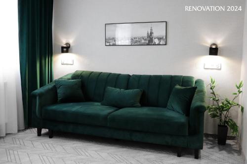 a green couch sitting in a living room at Hotel Polonia Centrum in Wrocław