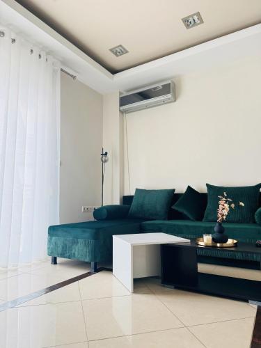 a living room with a green couch and a table at Elite Haven in Alexandroupoli