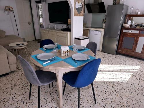 Il dispose d'une cuisine et d'une table à manger avec des chaises bleues. dans l'établissement La brise marine - proche de la mer, à Valras-Plage