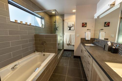ein Badezimmer mit einer Badewanne, einem Waschbecken und einem Spiegel in der Unterkunft Pearl Penthouse by Jackson Vacations in Jackson