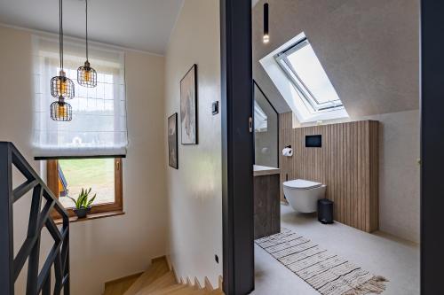 a bathroom with a toilet and a skylight at Domek Bajkowy Widok in Maniowy