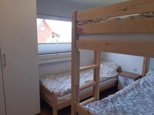 two bunk beds in a room with a window at Letnisko Skarpa in Giżycko