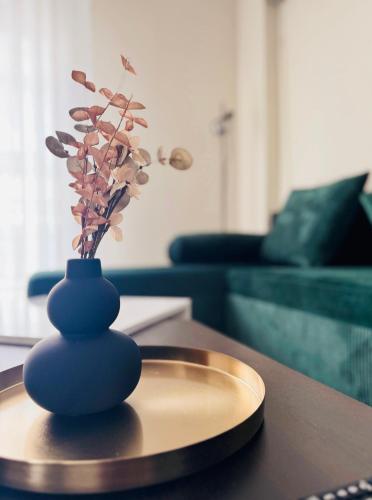 a blue vase with flowers in it on a table at Elite Haven in Alexandroupoli