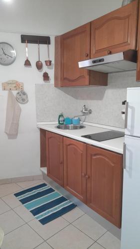 a kitchen with wooden cabinets and a white refrigerator at Casa Marina 50 mt dal mare in Imperia