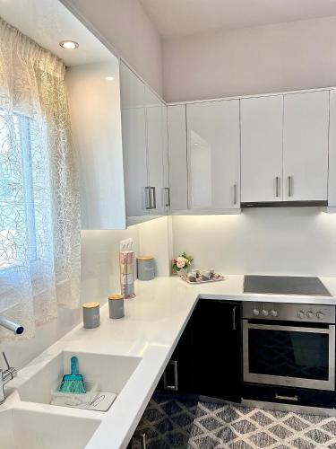 a kitchen with white cabinets and a sink at Marble luxury villa in Neápolis