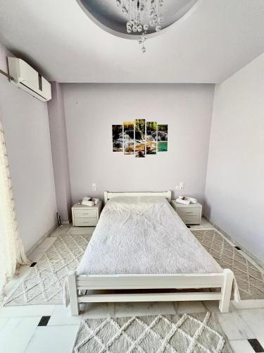- une chambre blanche avec un lit et un lustre dans l'établissement Marble luxury villa, à Neápolis