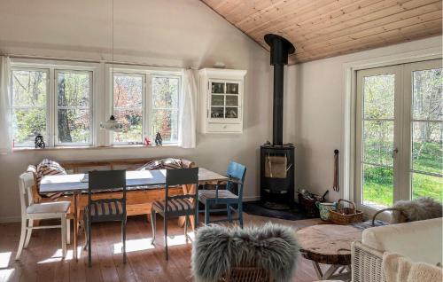 uma sala de jantar com uma mesa e um fogão a lenha em Cozy Home In Frederiksvrk With Kitchen em Frederiksværk