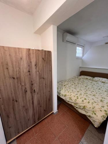 1 dormitorio con 1 cama y puerta de madera grande en Babici 3 en Hiseti