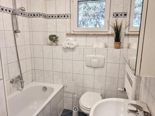 een badkamer met een bad, een toilet en een wastafel bij Apartment in Offenbach am Main in Offenbach
