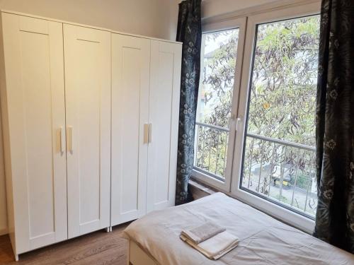 een slaapkamer met een bed en een groot raam bij Apartment in Offenbach am Main in Offenbach