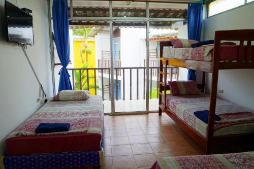 a room with three bunk beds and a balcony at Hotel Canoa´s Wonderland in Canoa