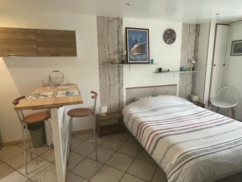ein kleines Schlafzimmer mit einem Bett und einem Schreibtisch in der Unterkunft Studio indépendant avec jardin privatif in Le Lorey