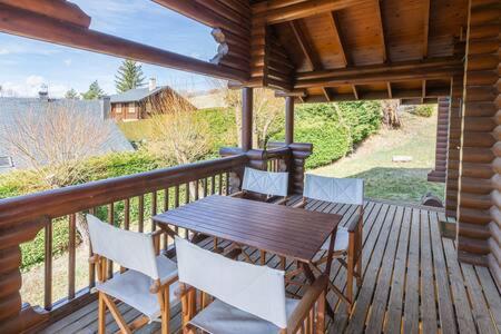 une terrasse en bois avec une table et des chaises en bois dans l'établissement La Cabane de Bajanda, à Estavar