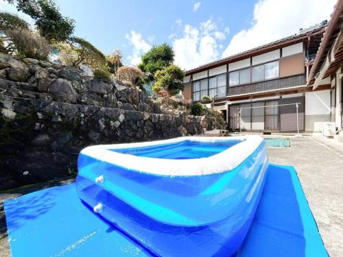 una gran piscina inflable frente a un edificio en NEW OPEN！田舎の一棟貸住宅、お庭でBBQやプール遊びができる宿。限定５組オープン特別価格！ en Fukuchiyama