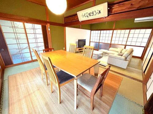 comedor con mesa, sillas y sofá en NEW OPEN！田舎の一棟貸住宅、お庭でBBQやプール遊びができる宿。限定５組オープン特別価格！ en Fukuchiyama