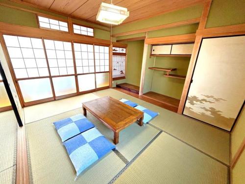 福知山New Open !! 田舎の一棟貸 お庭でBBQやプール遊びができる貸切の宿 3ぴーす的带桌子的客房位于带窗户的房间内