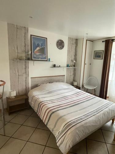 a bedroom with a bed with a striped blanket at Studio indépendant avec jardin privatif in Le Lorey