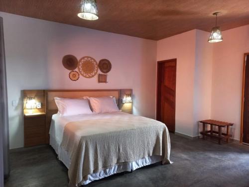 um quarto com uma cama e dois pratos na parede em Pousada Lençóis Eco Villa em Santo Amaro