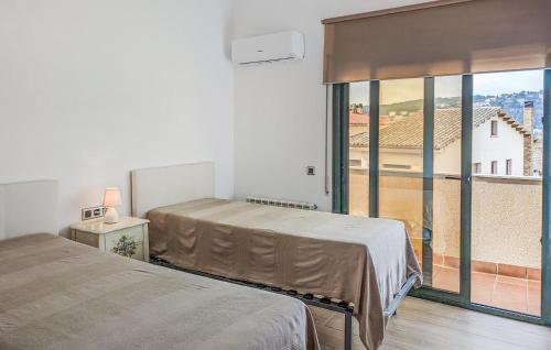 トッサ・デ・マールにあるAmazing Home In Tossa De Mar With 3 Bedrooms, Wifi And Outdoor Swimming Poolのベッドルーム1室(ベッド2台、大きな窓付)