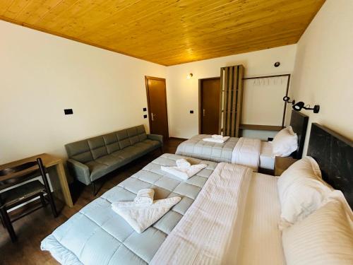 a hotel room with two beds and a couch at Bujtina Terthorja in Theth