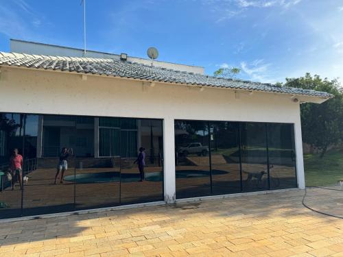 a building with sliding glass doors with people and a dog at sobrado luxo in Trindade